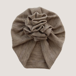 Zachte beige merino wollen turban met ruffel voor baby's. De turban is handgemaakt en verkrijgbaar in verschillende maten.